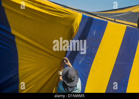 Hispanic workmen in Laguna Niguel, CA, cover a home with a gasproof tent prior to fumigation for termite infestation. Stock Photo