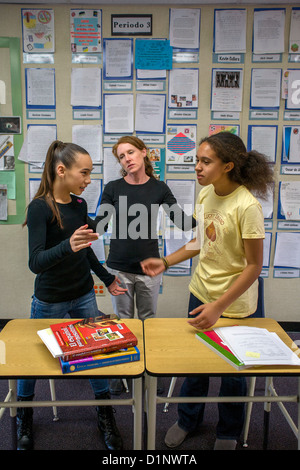 An intermediate school teacher resolves a dispute between two students in her San Clemente, California, classroom. Stock Photo