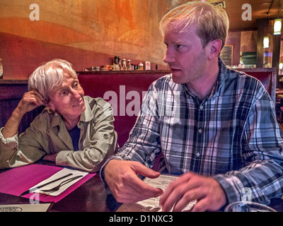 An older woman exemplifies the 'cougar,' a woman who favors a much younger man in Brooklyn, New York, restaurant. MODEL RELEASE Stock Photo