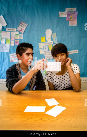 A Hispanic junior high school student tests his classmate's math skills using flash cards in a San Clemente, CA, classroom. Stock Photo
