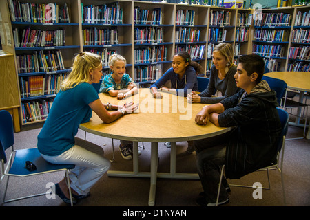 A junior high school counselor meets with a multiethnic group of students in a San Clemente, CA, school library. Stock Photo