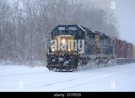 Freight train moves through snow storm in upstate New York, US. Stock Photo