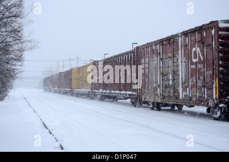 Freight train moves through snow storm in upstate New York, US. Stock Photo