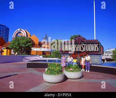Family by entrance sign to Universal Studios, Orlando, Florida, United States of America Stock Photo