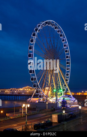 The wheel and pier on the coast at night in Brighton, East Sussex Stock Photo