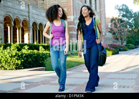 Mixed race college students walking together Stock Photo