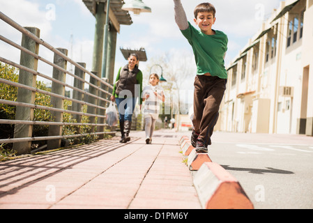 Boy balancing on edge of sidewalk Stock Photo