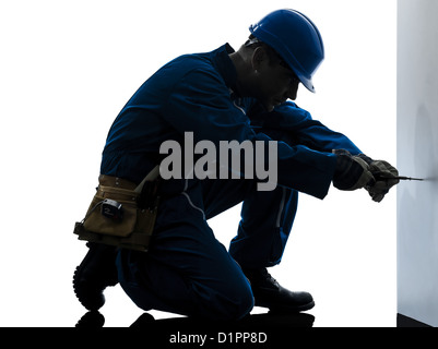 one  man construction worker screwdriving silhouette in studio on white background Stock Photo