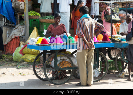 South Indian woman selling coloured powder used for making rangoli designs at festivals from a cart on the street. Andhra Pradesh, India Stock Photo