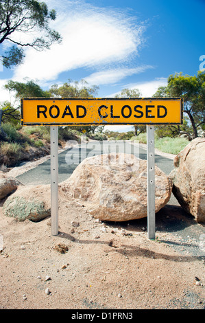 Road closed sign with large boulders on the road Stock Photo