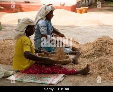 Two women winnowing the chaff - method developed by ancient cultures for separating grain from chaff Stock Photo