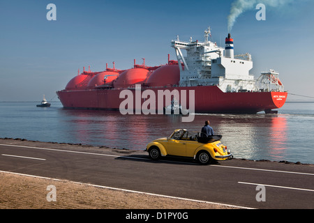 The Netherlands, Rotterdam, Port. Norwegian tanker transporting Natural Liquid Gas ( LNG ). Man in Volkswagen Beetle looking. Stock Photo