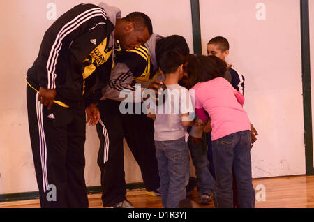 U.S. Army All-American players huddle with children from SA Youth at the St. Paul United Methodist Church in San Antonio on Jan 2. SA Youth works toward developing character, strength, talent and skills for high-risk urban youth throughout San Antonio. The U.S. Army All-American Bowl select the nation's top high school football players to compete in the bowl game scheduled for kickoff in the Alamodome on Jan. 5. (U.S. Army Reserve photo by Sgt. Andrew Valles, 205th Public Affairs Operations Center) Stock Photo