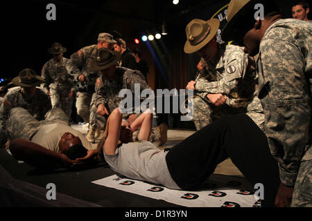 Drill sergeants motivate Soldiers and All-American selectees to push out more sit ups during the All-American Soldier Hero Challenge Jan. 2 at Sunset Station. Soldiers, along with All-American high school band members and football players, competed in pushups, situps and an eating relay event. (U.S. Army photo by Staff Sgt. Keith Anderson, Army North PAO) Stock Photo