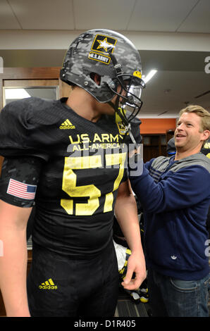 Wyatt Teller (left), from Liberty High School receives some help adjusting his uniform at the Alamodome in San Antonio Jan. 2, 2013. Teller is one of 90 student athletes selected to participate in the U.S. Army All-American Bowl, scheduled to be held Jan. 5. The Army has hosted the All-American Bowl in San Antonio since 2002, highlighting the best high school athletes from across the nation. (U.S. Army Reserve photo by Sgt. 1st Class Carlos J. Lazo, 302nd Mobile Public Affairs Detachment) Stock Photo