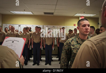 Then, Sgt. Hector E. Orozco, stands to be meritoriously promoted to the next rank of staff sergeant, during a ceremony at the Marine Corps Recruiting Station Phoenix Headquarters in Phoenix, Jan. 2, 2013. Orozco, a native of Los Angeles, and an aircraft electronic countermeasures systems technician by trade, has been a recruiter in the Phoenix region since July, 2011. 'To get promoted is one thing. Everybody out here on recruiting duty is hand selected and personally screened, so you're already dealing with an A-List group of people to begin with,' said Maj. Steven M. Ford, commanding officer  Stock Photo