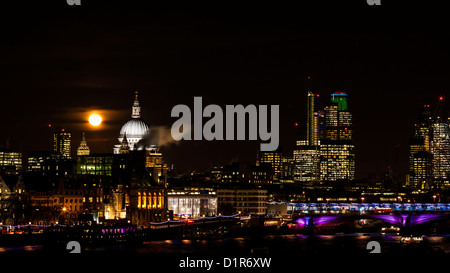 London: Full moon rise behind London Skyline and St Paul Stock Photo