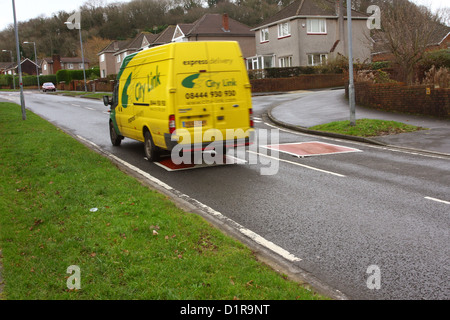City link delivery van speeding over traffic calming humps on a residential housing estate Stock Photo