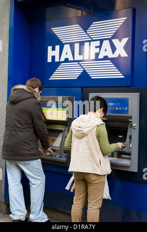 People withdrawing money from a Halifax Bank cash machine Stock Photo