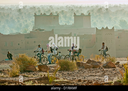 Morocco, near Zagora, kasbah Ziwane. Sunrise over oasis and palm trees. kasbah and ksar. Children going to school. Stock Photo