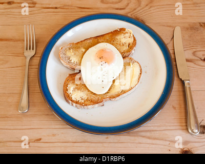 A fried egg on two slices of buttered toasted Rye Bread ready to eat Stock Photo