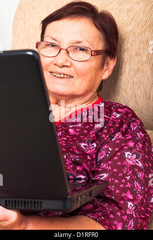 Close up of happy smiling senior woman using laptop. Stock Photo