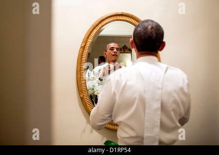 US President Barack Obama ties his white tie before the Alfred E. Smith dinner October 18, 2012 in New York, NY. Although the dinner is an annual event, every four years, the two presidential nominees attend the dinner only a few weeks before the election. Stock Photo