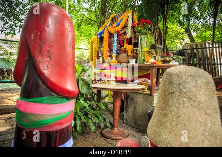 Jan. 4, 2013 - Bangkok, Thailand - The spirit house at the Lingam Shrine in Bangkok. The Lingam Shrine is a phallus garden behind the Swissotel Nai Lert Park Hotel, an exclusive 5 star hotel in Bangkok. Clusters of carved stone and wooden shafts surround a spirit house and shrine built by a Bangkok millionaire to honour Jao Mae Thap Thim, a female deity thought to reside in a banyan tree on the site. According to Bangkok legend, a woman who made an offering at the shrine had a baby after praying at the shrine, and it has received a steady stream of worshippers ever since. Stock Photo