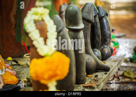 Jan. 4, 2013 - Bangkok, Thailand - Small stone penises at the Lingam Shrine in Bangkok. The Lingam Shrine is a phallus garden behind the Swissotel Nai Lert Park Hotel, an exclusive 5 star hotel in Bangkok. Clusters of carved stone and wooden shafts surround a spirit house and shrine built by a Bangkok millionaire to honour Jao Mae Thap Thim, a female deity thought to reside in a banyan tree on the site. According to Bangkok legend, a woman who made an offering at the shrine had a baby after praying at the shrine, and it has received a steady stream of worshippers ever since.  Stock Photo
