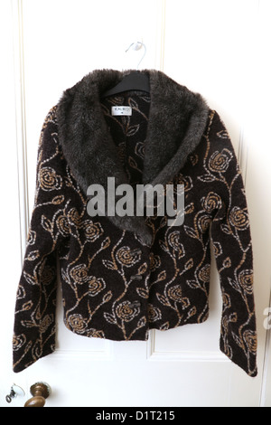 Brown Kaliko Jacket With Floral Pattern And Faux Fur Collar Hanging On Door Stock Photo