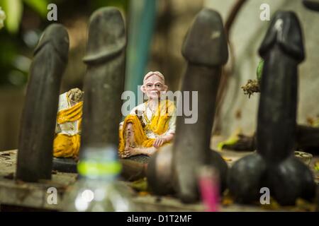 Jan. 4, 2013 - Bangkok, Thailand - A statue of a Buddhist monk is flanked by carved stone penises at the Lingam Shrine, a garden where clusters of carved stone and wooden phalluses surround a spirit house and shrine built by a Bangkok millionaire to honour Jao Mae Thap Thim, a female deity thought to reside in a banyan tree on the site. (Credit Image: © Jack Kurtz/ZUMAPRESS.com) Stock Photo