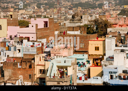 A view of the colorful rooftops of Udaipur Rajasthan India with some people and washing lines and geometric shapes of buildings Stock Photo