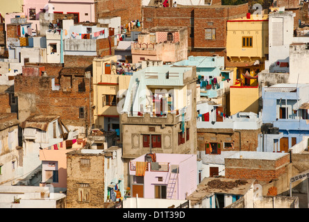 A view of the colorful rooftops of Udaipur Rajasthan India with some people and washing lines and geometric shapes of buildings Stock Photo