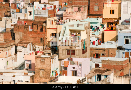 A view of the colorful rooftops of Udaipur Rajasthan India with some people and washing lines and geometric shapes of buildings Stock Photo