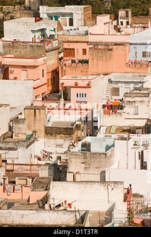 A view of the colorful rooftops of Udaipur Rajasthan India with some people and washing lines and geometric shapes of buildings Stock Photo