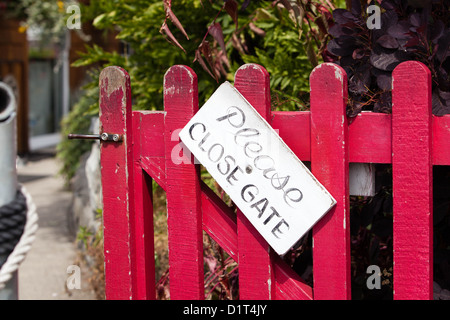 Wooden door with sign 'please close gate' Stock Photo