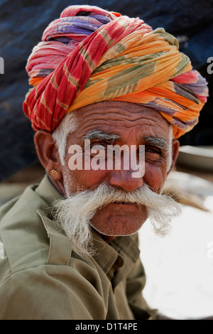 A portrait of an elderly Indian man in a colorful turban and with a big moustache looking at the camera in Pushkar Rjasthan Stock Photo