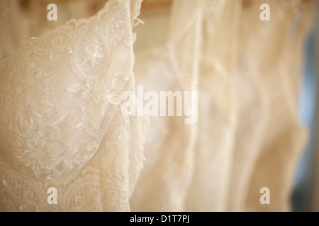 New wedding dresses hanging on a rack in wedding dress shop! Stock Photo