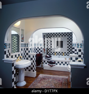 BATHROOMS Contemporary Dark green and white checkerboard pattern ceramic tiles on walls and above tub Arched ceiling painted Stock Photo