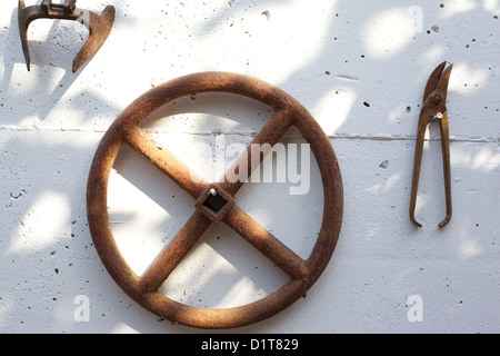 Old, rusting, farm tools hanging on a wall Stock Photo