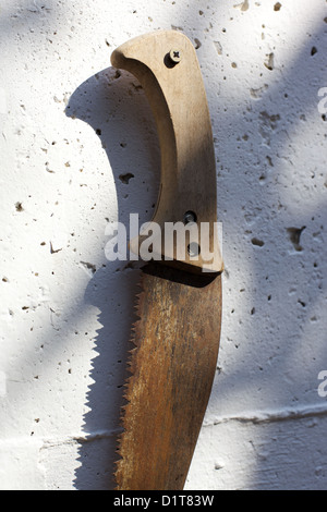 Old, rusting, farm tools hanging on a wall Stock Photo