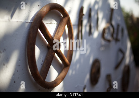 Old, rusting, farm tools hanging on a wall Stock Photo