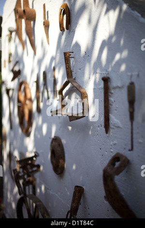 Old, rusting, farm tools hanging on a wall Stock Photo