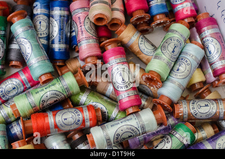 Bobbins of  Tubino cotton thread at a flea market stall. The references are engraved on the head of the Tubino Stock Photo