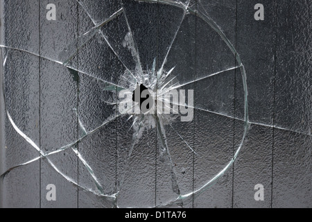 broken window glass with a hole in the middle Stock Photo