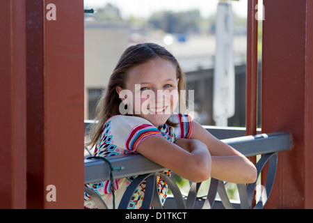 A young pre teen Caucasian girl modeling 1960s style tie dyed clothes. She has blue eyes and  a playful warm smile. She is weari Stock Photo