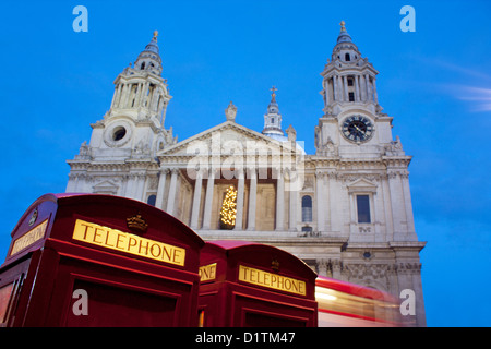 St Paul's Cathedral at night / twilight / dusk with traditional red telephone boxes in foreground City of London England UK Stock Photo