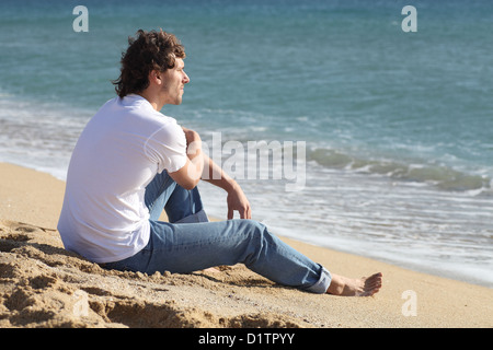 Man thinking and watching the sea on the beach Stock Photo