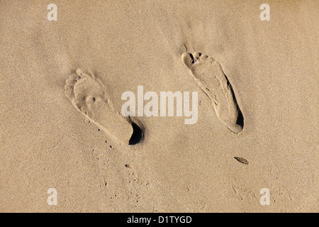 Two human footprints in the sand in morning light Stock Photo - Alamy