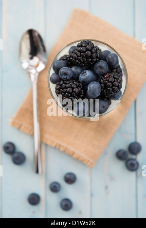 Blueberries and blackberries in natural yoghurt dessert or snack. Presented in a glass tumbler. Stock Photo